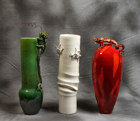 A green vase, red vase and white vase with lizrd figurinesby Mirta Morigi