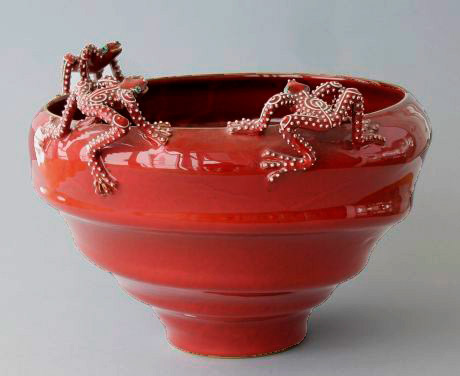 Red glaze vessel with three white spotted red frogs on the rim by Mirta-Morigi