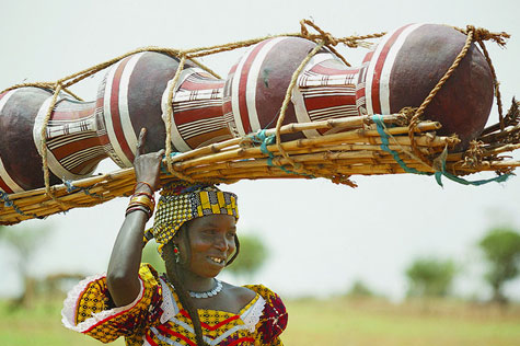 Woman carrying traditional water pots for sale in Niger