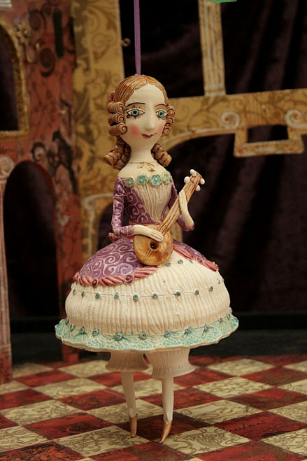 Young-girl-in-purple-dress-playing-mandolin.-Ceramic-bell,-sculpture.