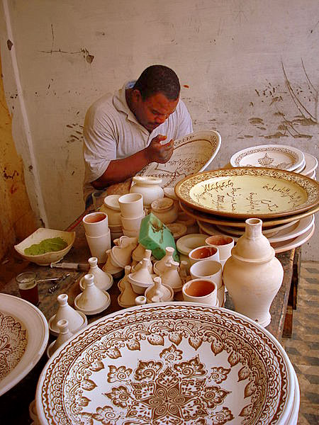 Moroccan Ceramic Artist painting a large charger