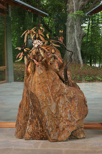 Ceramic rhododendron growing from a rock sculpture 