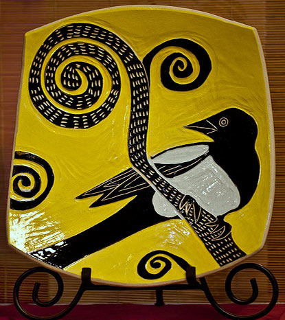 Julia Janeway sgraffito magpie plate, black and white bird on mustard yellow background