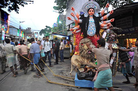 Indian men dragging a female deity goddess thru the streets