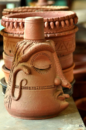 terracotta pot of man covered in snakes