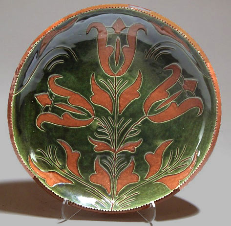 Plate with Bbrnt orange plant motif on olive green background