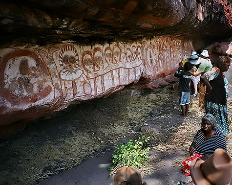 wandjina rock painting on a vertical wall