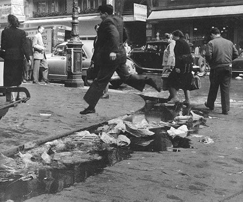 French photographer Robert Doisneau - a man jumping over rubbish in the gutter