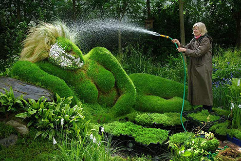 Gardener watering a floral sculpture at the Chelsea- Flower Show
