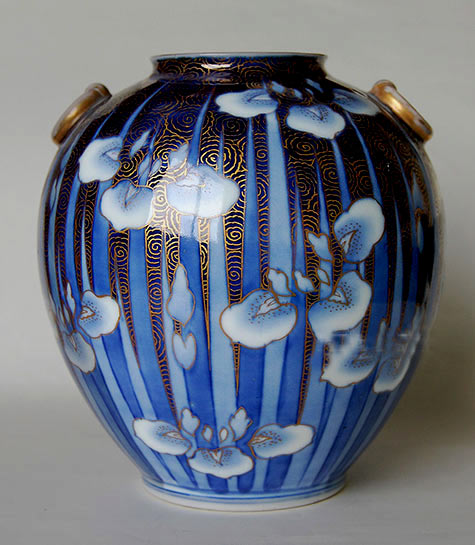 Antique japanese porcelain vase with white flower motifs on a blue background