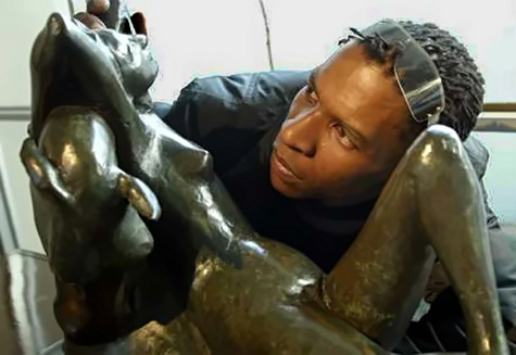 Henri Mokoka inspects a bronze statue