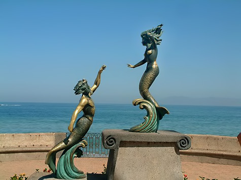 Triton and Nereida by Carlos Espino two mermaid statues by the sea
