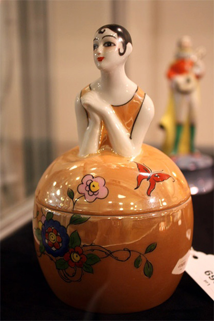 Figural dresser box Noritake Art Deco- A.H.-Wilkens-Noritake-figural-dresser-jar-Pierrette-in-a-caramel-lustre-dress-with-flowers-and-butterfly