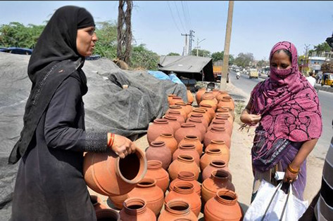 A woman sells pots at Hassan Nagar in city of Hyderabad