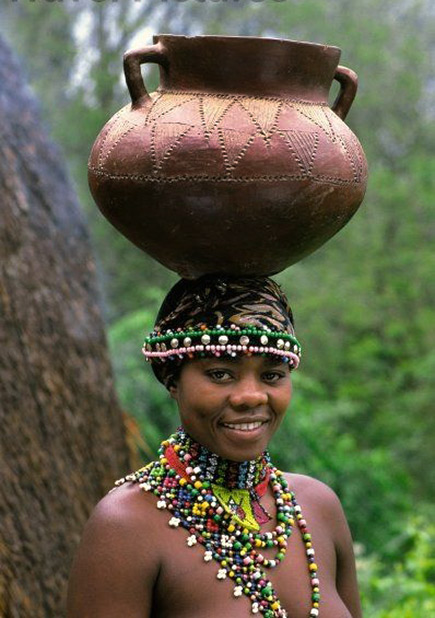 Africa Zulu girl carrying a clay pot on her- ead
