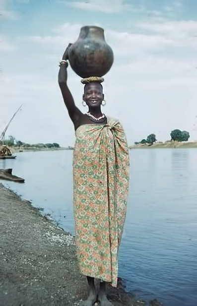 Nuer woman carrying a pot.
