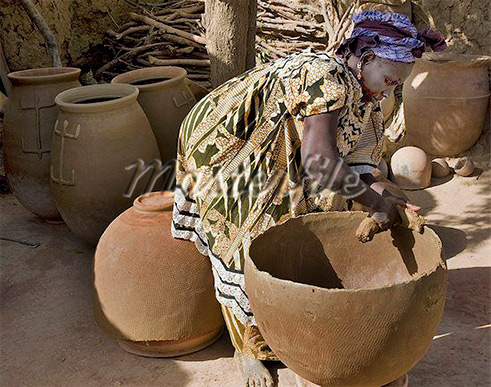Female potter making large clay pots at the village of Kalabougou