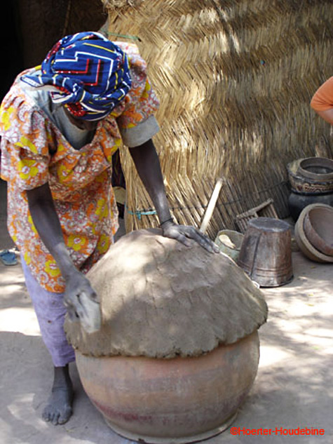 tribal woman forming clay in Mali
