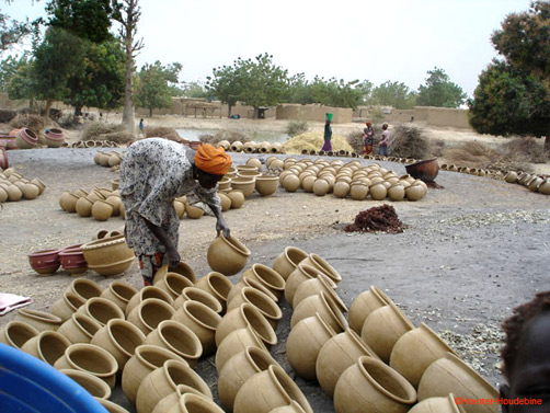 Lady stacking Kalabougou pots 