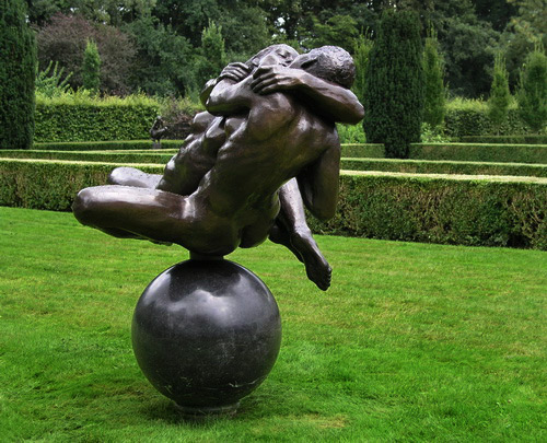 Netherlands sculpture by Eddy-Roos A bronze sculpture of a couple kissing on a ball