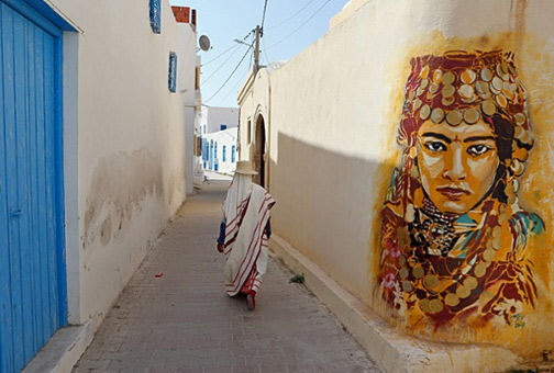 A-Tunisian-woman-walks-past-a-mural-by-Spanish-artist-Btoy.-Photograph--Mohamed-Messara-EPA