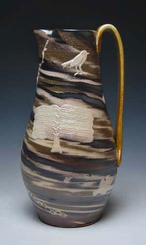 Matthew-Metz--Pitcher.-Brown striped Porcelain with a white tree and bird motif with a gold handle