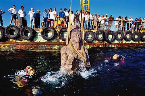 Onlookers watch Franck Goddio and his team watch the raising of a colossal Egyptian statue of red granite from the Mediterranean Sea