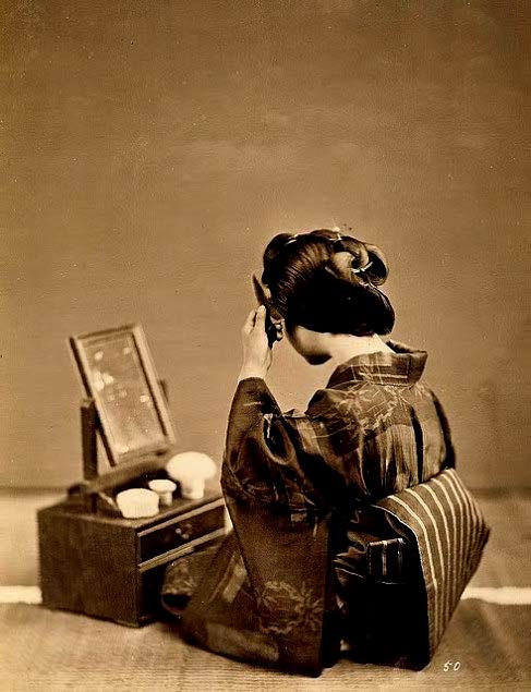 Vintage photo of a Geisha preparing hair