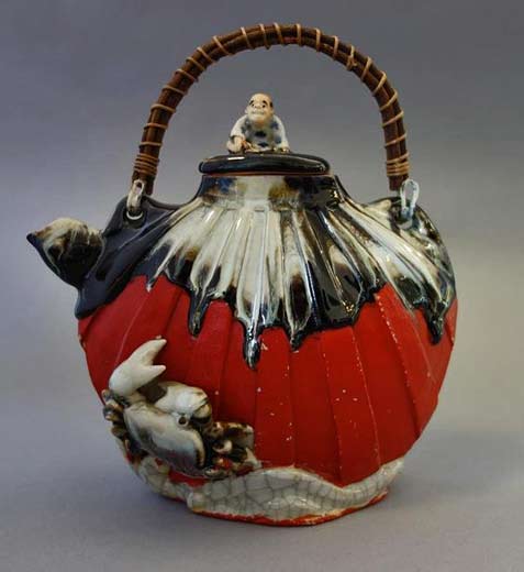 Japanese-Sumida-Gawa-earthenware-teapot.-The-finial-depicts-a-seated-male-figure.-Raised-crab-and-sea-motif.