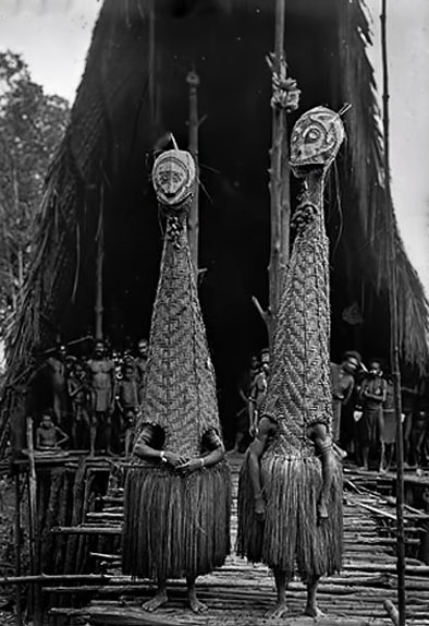 Masked-dancers-in-front-of-the-men’s-longhouse-at-Tovei-village-Urama-Island-1921-Margaret-Whitlam-Gallery-Sydney photo Frank Hurley