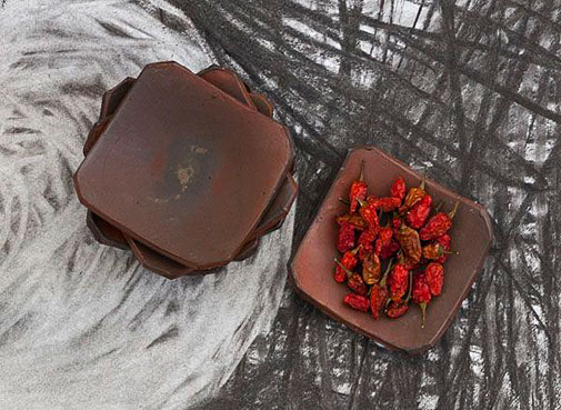 Catherine White---ceramic terracotta platters with red chillies on painted paper