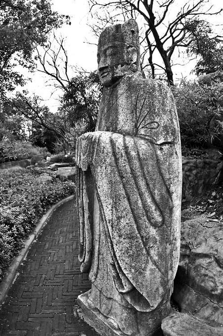 Statue-of-a-Standing Buddhist-monk,-located-in-a-garden-within-Seven-Star-Park,-Guilin,-China