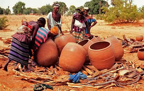 Arranging large Bamana pots for firing - Mali