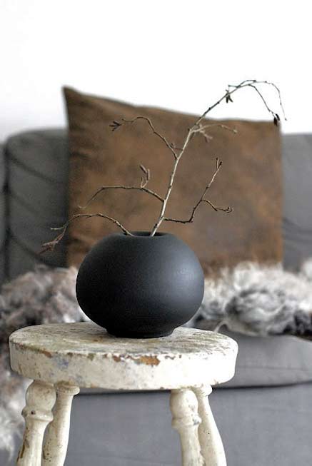 black ceramic globular vessel on white stool