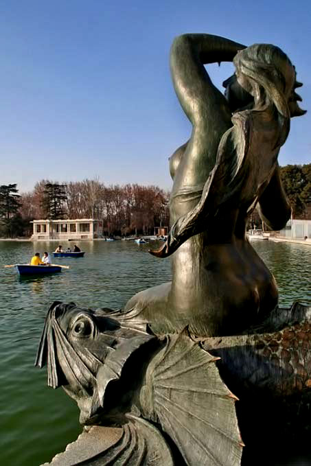 Seated mermaid-statue next to a lake - sculpture Madrid, Spain