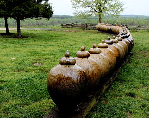 Daniel Johnston-Pots On The Lawn - a single row of pottery