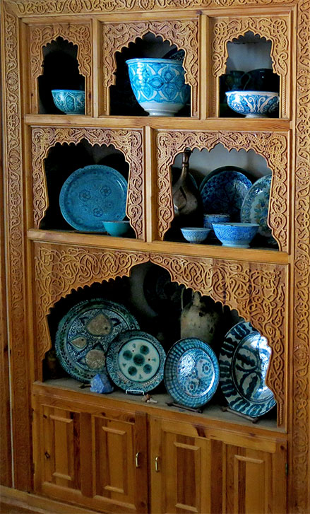 Rustam Usmanov ceramic 'ishkor' blue wares in carved cabinet