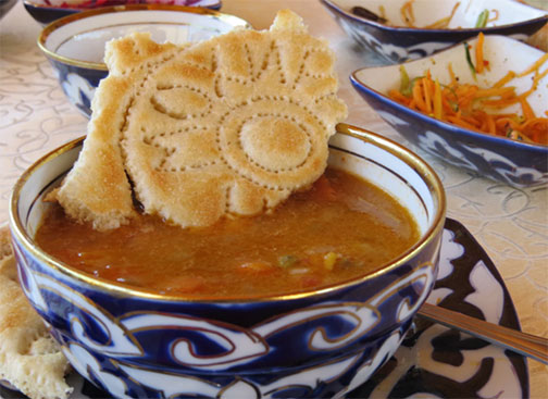 Traditional-Uzbek-mastava-soup-–-with-lamb,-vegetables-and-rice-–-served-with-patterned-flatbreads--Hazel-Plush