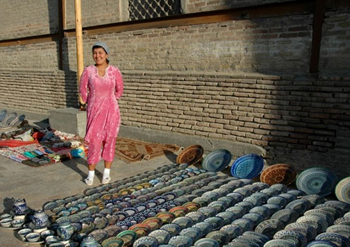 Female street vendor in Bukhara with ceramic wares
