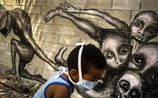A-boy-plays-in-front-of-a-mural-by-Yuriel-P-called-Marcha-Hacia-la-Oscuridad,-or-Move-Toward-Darkness,-in-Havana